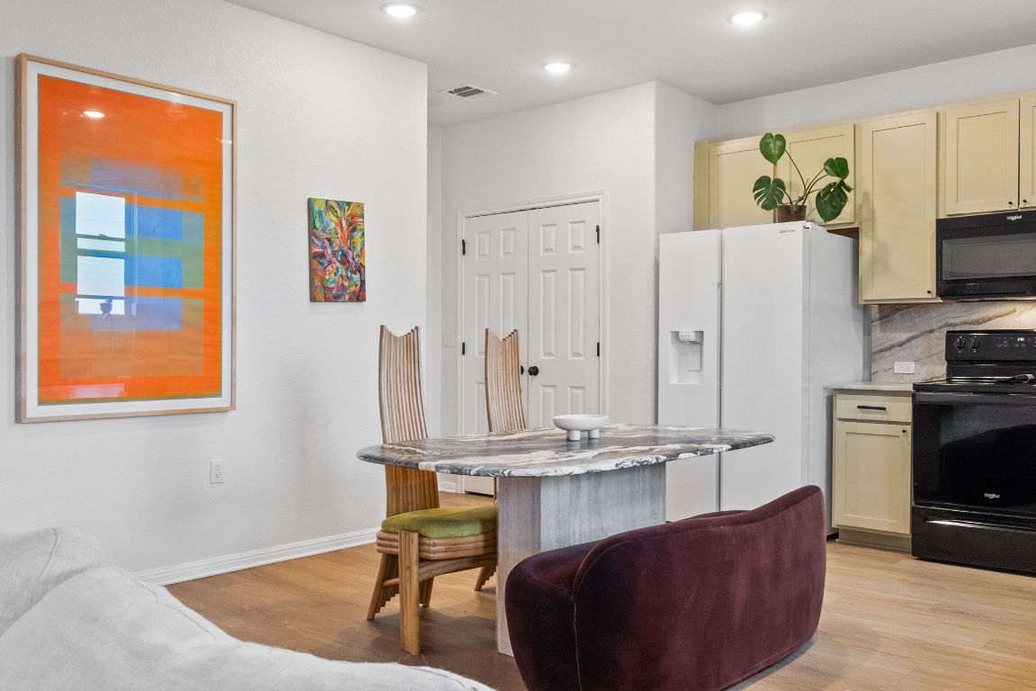 6703 Routenburn Street Austin, TX 78754 - Photo 11 of 34 a living room with stainless steel appliances kitchen island granite countertop furniture a rug and a window