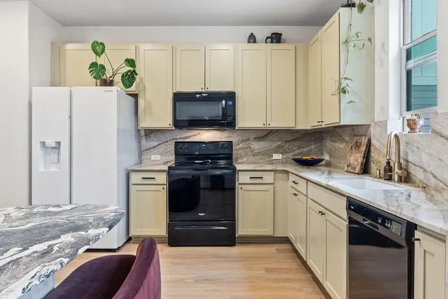 a kitchen with stainless steel appliances granite countertop a stove a sink and a refrigerator