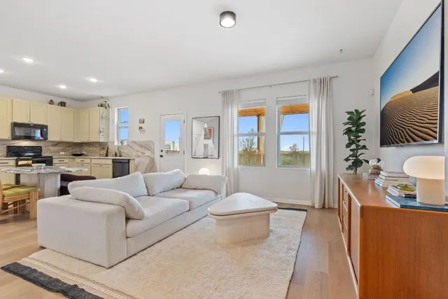 a living room with furniture and a view of kitchen