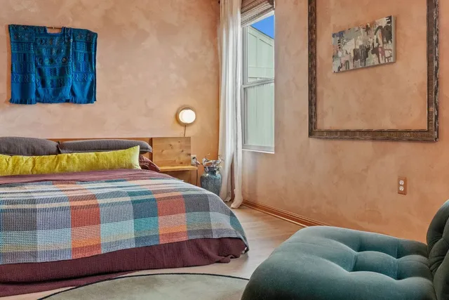 a bedroom with a bed and painting on the wall