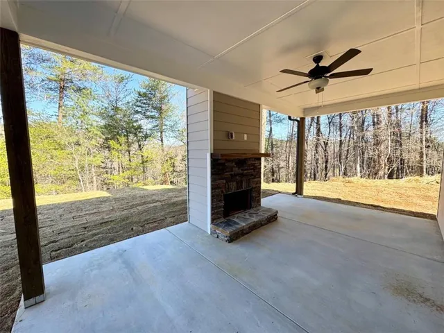 a view of an empty room with fireplace and a window