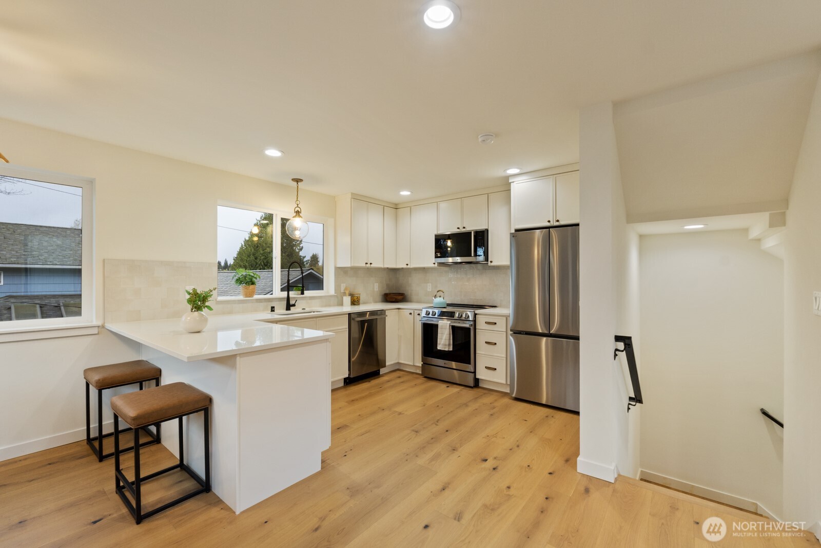 2725 Northeast 87th Street Seattle, WA 98115 - Photo 10 of 30 a kitchen with refrigerator a sink and chairs