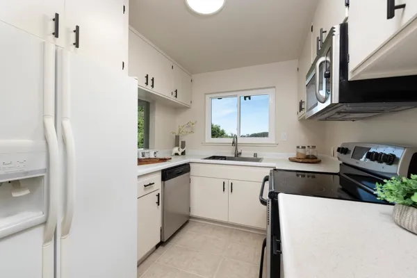 a kitchen with stainless steel appliances granite countertop a sink and a stove