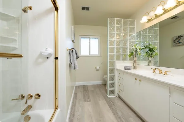 a bathroom with a tub sink and mirror