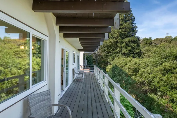 a view of balcony with wooden floor and fence