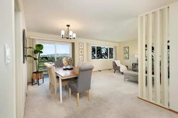 a living room with furniture a chandelier and a dining table