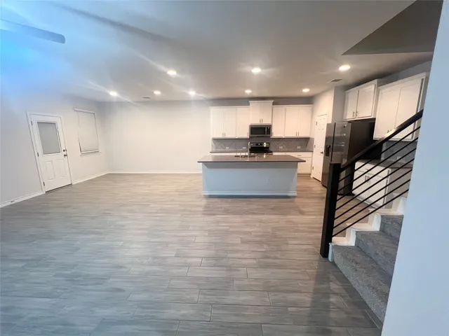 a view of kitchen with refrigerator microwave and stove