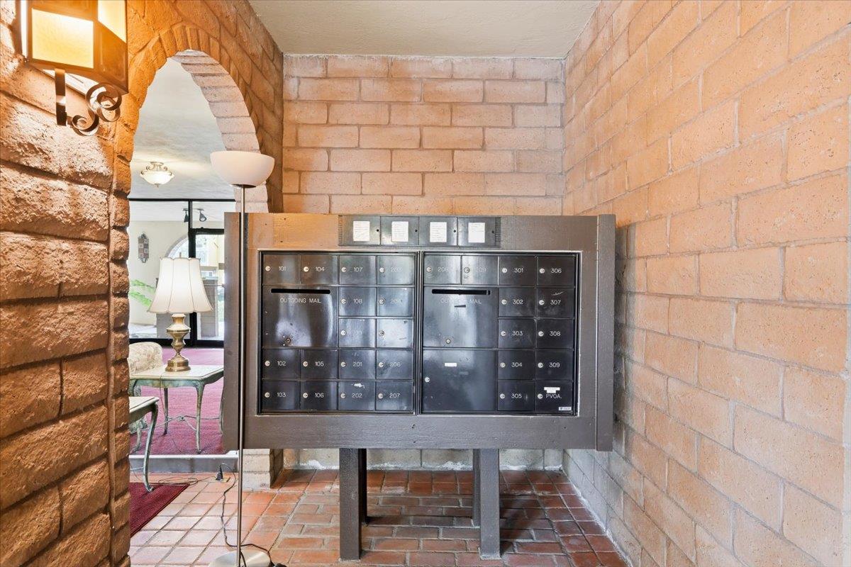 555 Palm Avenue, Unit 202 Millbrae, CA 94030 - Photo 7 of 40 a view of a brick wall with a bench and table in front of it