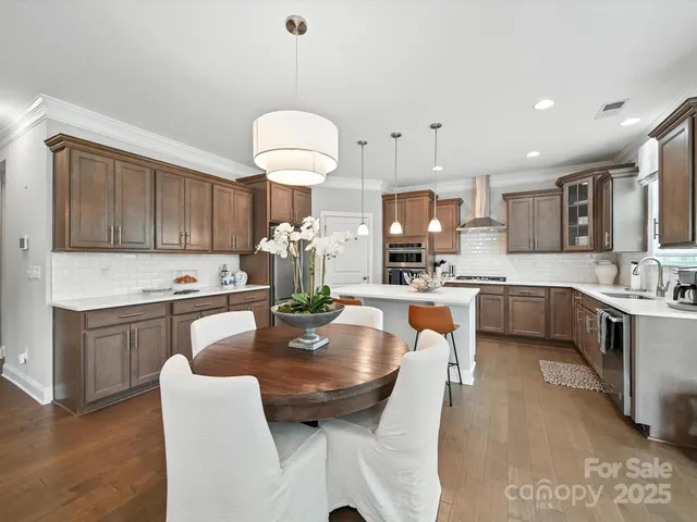 a kitchen with stainless steel appliances granite countertop a stove a sink a microwave a center island and furniture