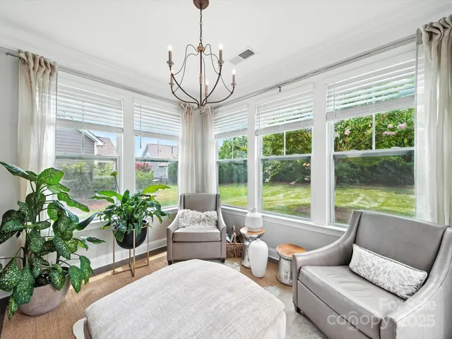 a living room with patio furniture and a chandelier