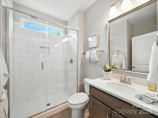 a spacious bedroom with a bed and a chandelier