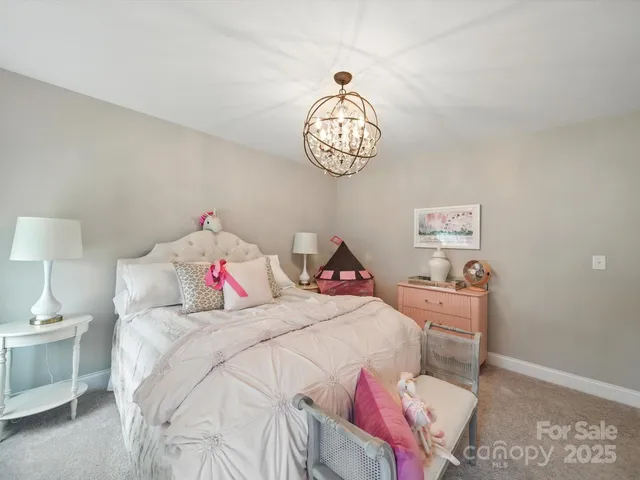 a living room with furniture a large window and a chandelier