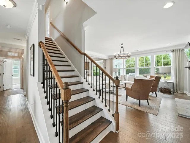a view of a hallway with wooden floor and stairs