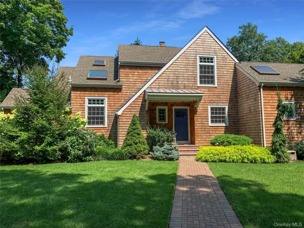 a front view of a house with a yard and potted plants