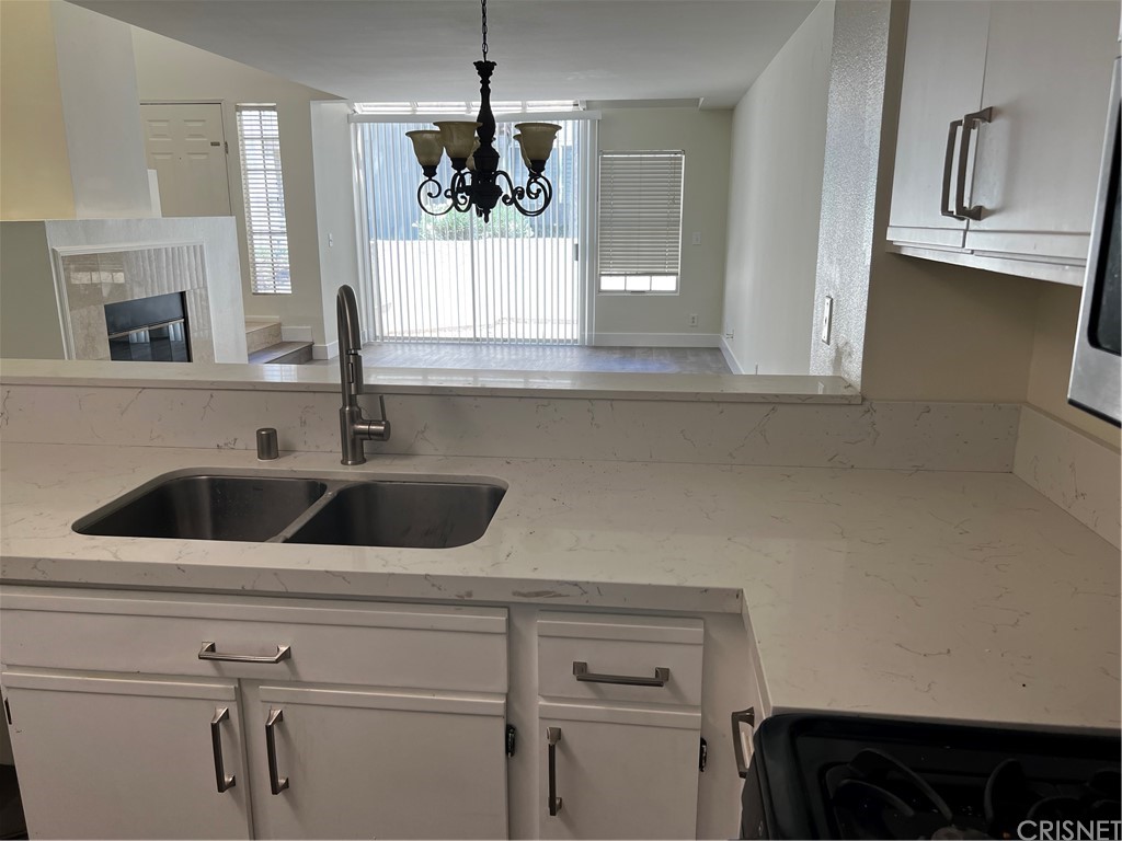 a view with granite countertop a sink and cabinets