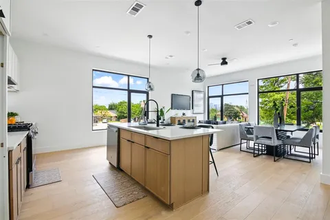a kitchen with kitchen island a large counter top space appliances and a large window
