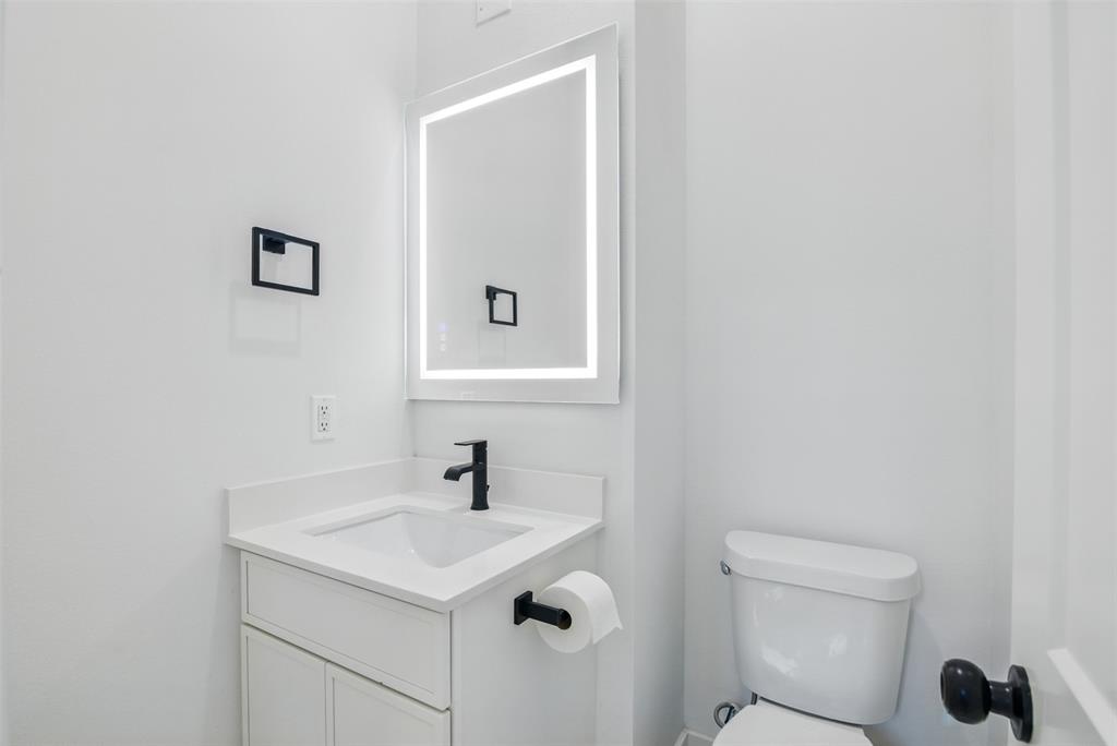 430 East 8th Street Dallas, TX 75203 - Photo 14 of 26 a bathroom with a sink a toilet and a mirror