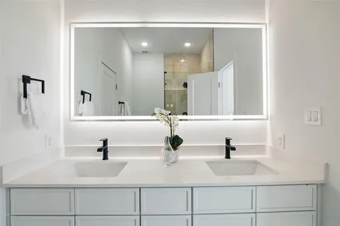 a bathroom with double vanity sink and mirror