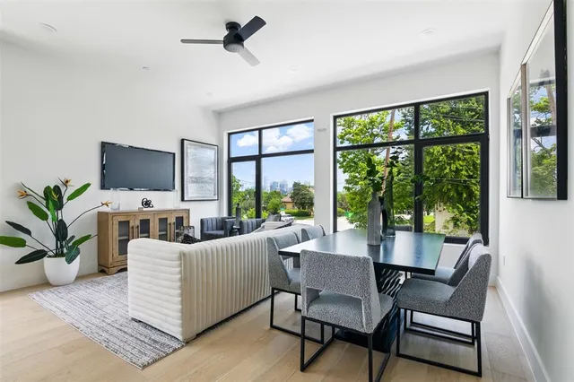 a living room with furniture tv and large windows