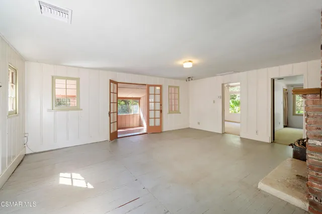 a view of an empty room with a fireplace and a window