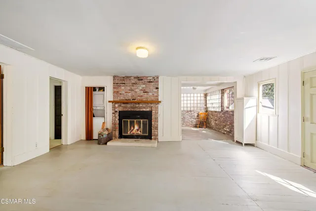 an empty room with windows fireplace and windows