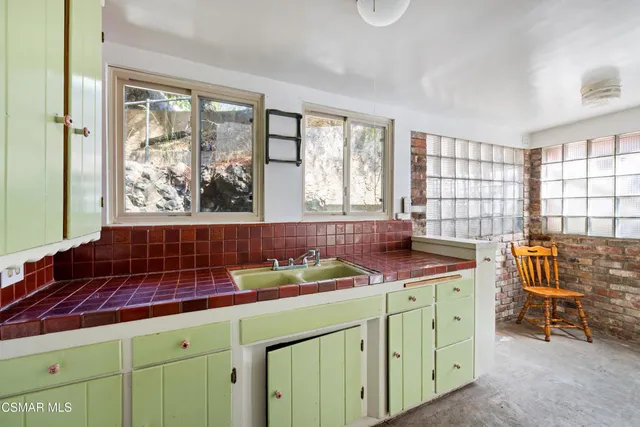 an empty room with windows and ceiling fan