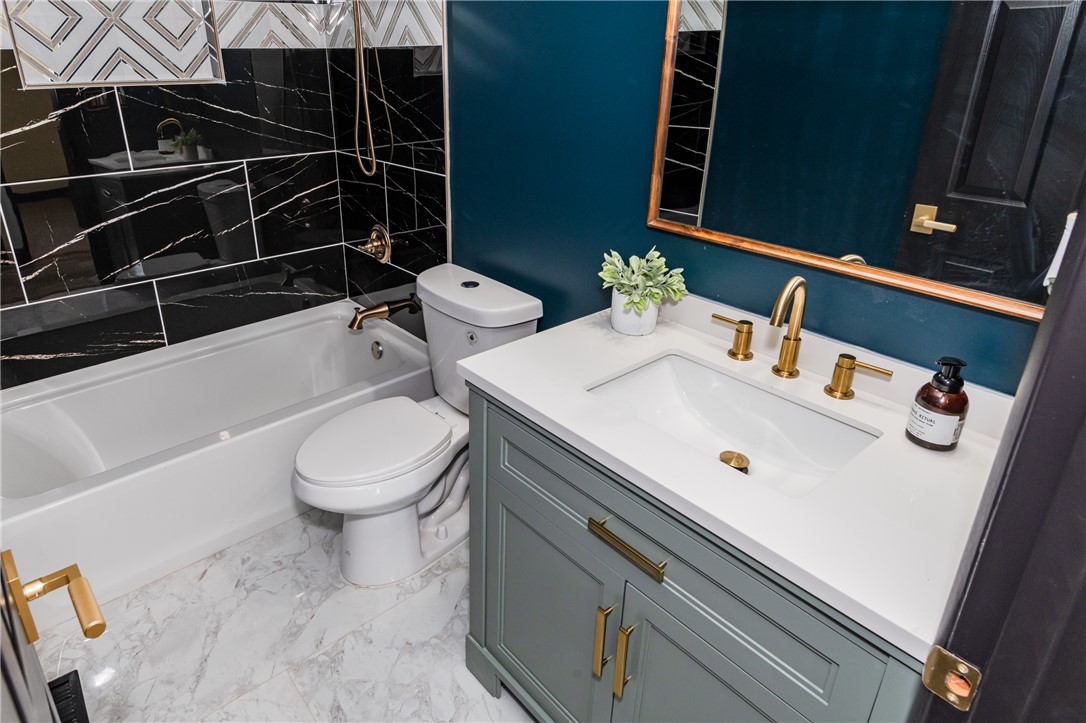5240 Haverfield Road Dayton, OH 45432 - Photo 40 of 58 This bathroom features a contemporary vanity with a sleek sink and elegant gold fixtures.