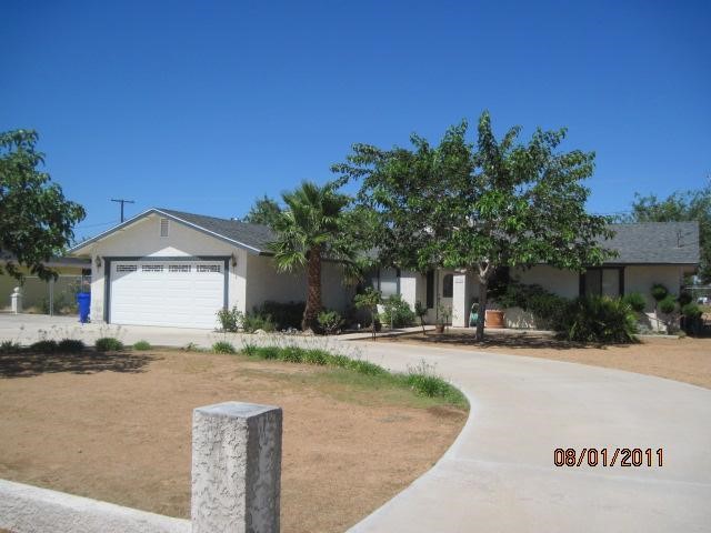 12008 Jamacha Road Apple Valley, CA 92308 - Photo 1 of 1 a front view of a house with a yard and a garage
