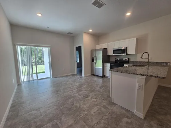 a kitchen with kitchen island granite countertop a stove top oven a sink with granite countertops and cabinets