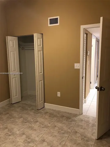 a view of a hallway with wooden floor and a living room