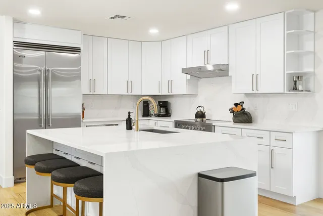 a living room with furniture kitchen and a large window