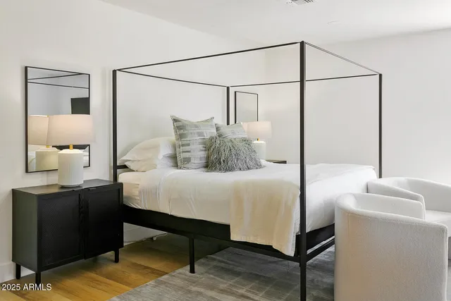 a bedroom with a bed and a painting on the wall