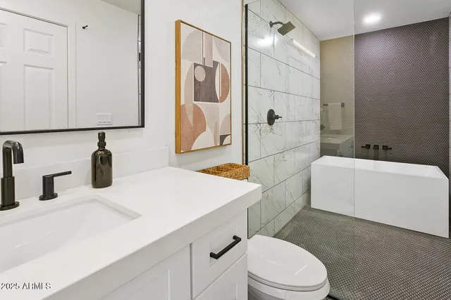 a bathroom with a sink a toilet and shower