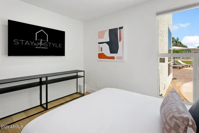 a bedroom with a bed and large window