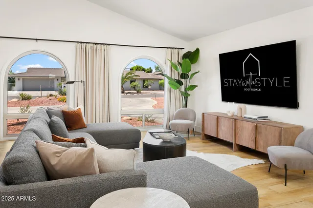 a view of a dining room with furniture a livingroom and chandelier