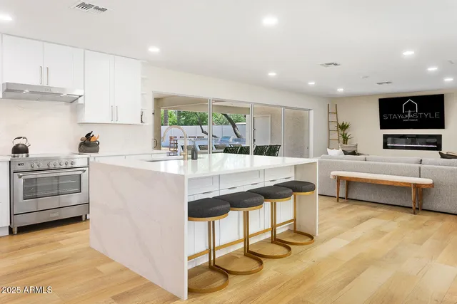 a kitchen with stainless steel appliances kitchen island a white counter top space a sink and cabinets