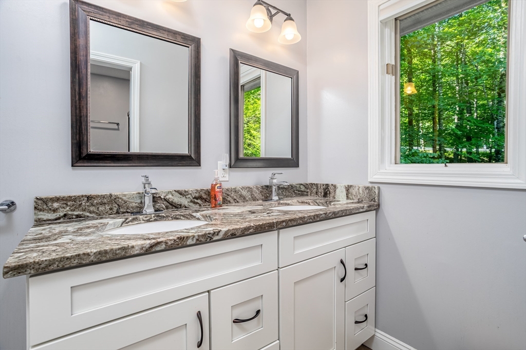 34 Hermit Road Alton, NH 03810 - Photo 23 of 37 a bathroom with a granite countertop sink and a mirror