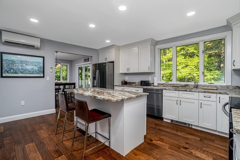 34 Hermit Road Alton, NH 03810 - Photo 4 of 37 a kitchen with kitchen island granite countertop wooden floors and white appliances