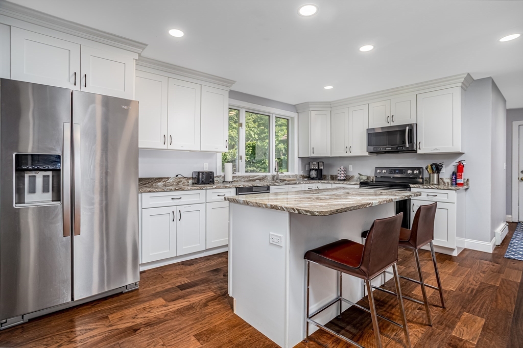 34 Hermit Road Alton, NH 03810 - Photo 6 of 37 a kitchen with granite countertop a refrigerator oven a sink a stove a dining table and chairs
