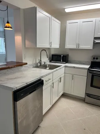 a kitchen with granite countertop white cabinets and white appliances