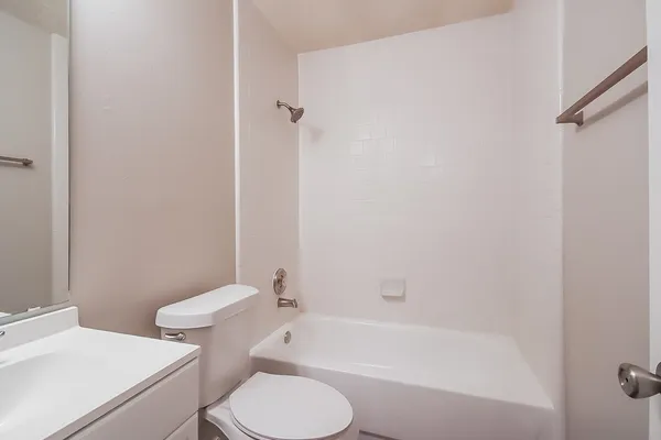 a white toilet and tub sitting next to a bathroom sink