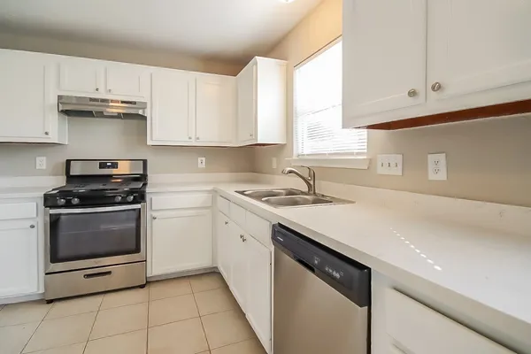 a kitchen with a sink stove top oven and cabinets