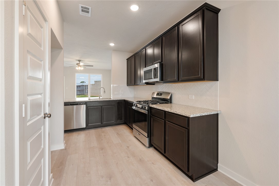 225 Cross Lane Caldwell, TX 77836 - Photo 12 of 38 a large kitchen with stainless steel appliances granite countertop a stove a sink and a refrigerator