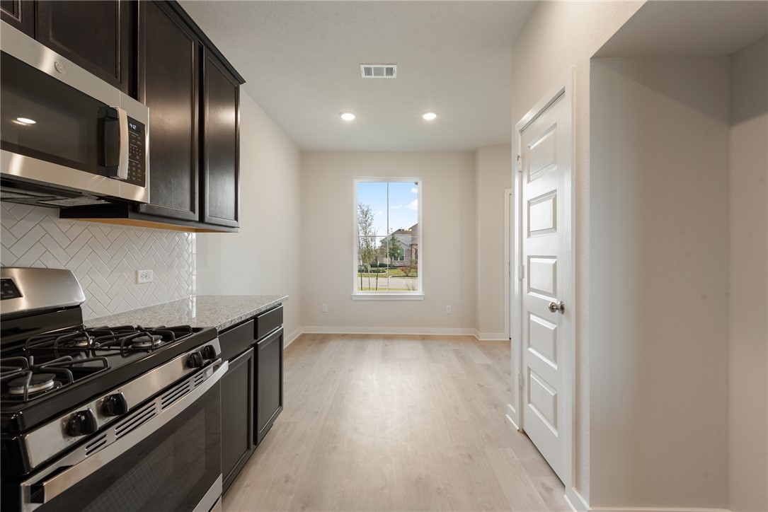225 Cross Lane Caldwell, TX 77836 - Photo 14 of 38 a kitchen with stainless steel appliances granite countertop a stove and a refrigerator