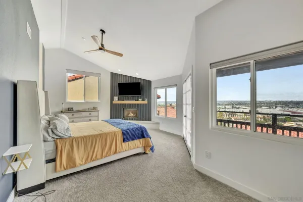a spacious bedroom with a bed and a flat tv screen next to a window