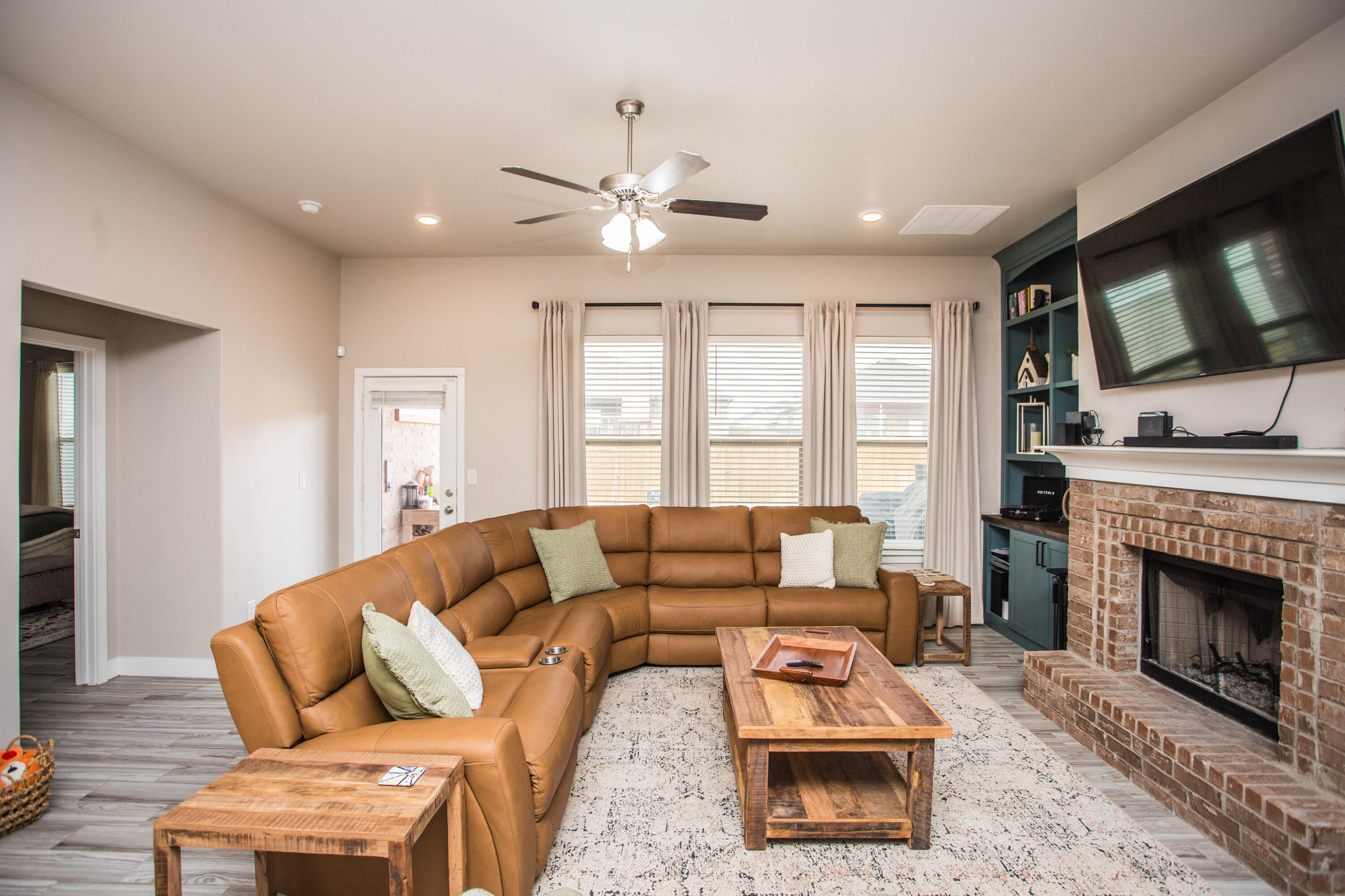1932 142nd Street Lubbock, TX 79423 - Photo 12 of 38 a living room with furniture a flat screen tv and a fireplace