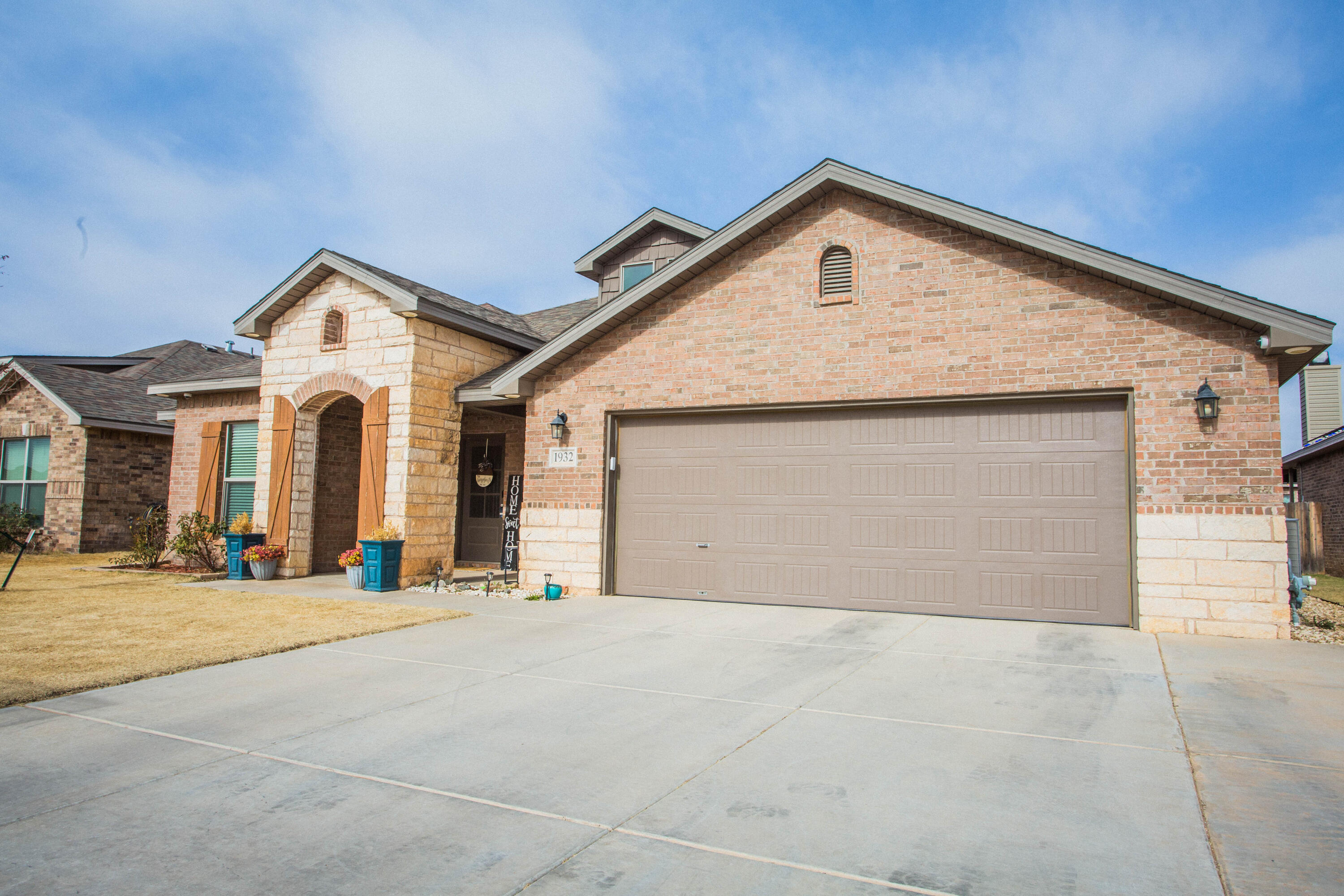 1932 142nd Street Lubbock, TX 79423 - Photo 3 of 38 a front view of a house with a yard and garage