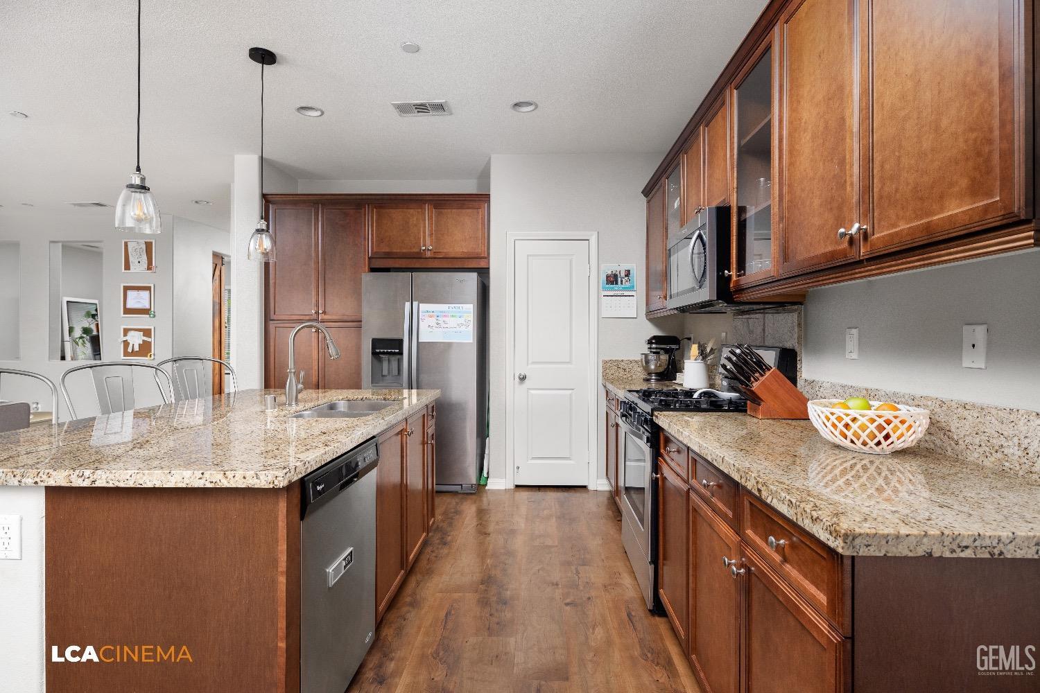 Undisclosed Address Bakersfield, CA 93313 - Photo 12 of 28 a kitchen with granite countertop kitchen island stainless steel appliances a sink stove and refrigerator