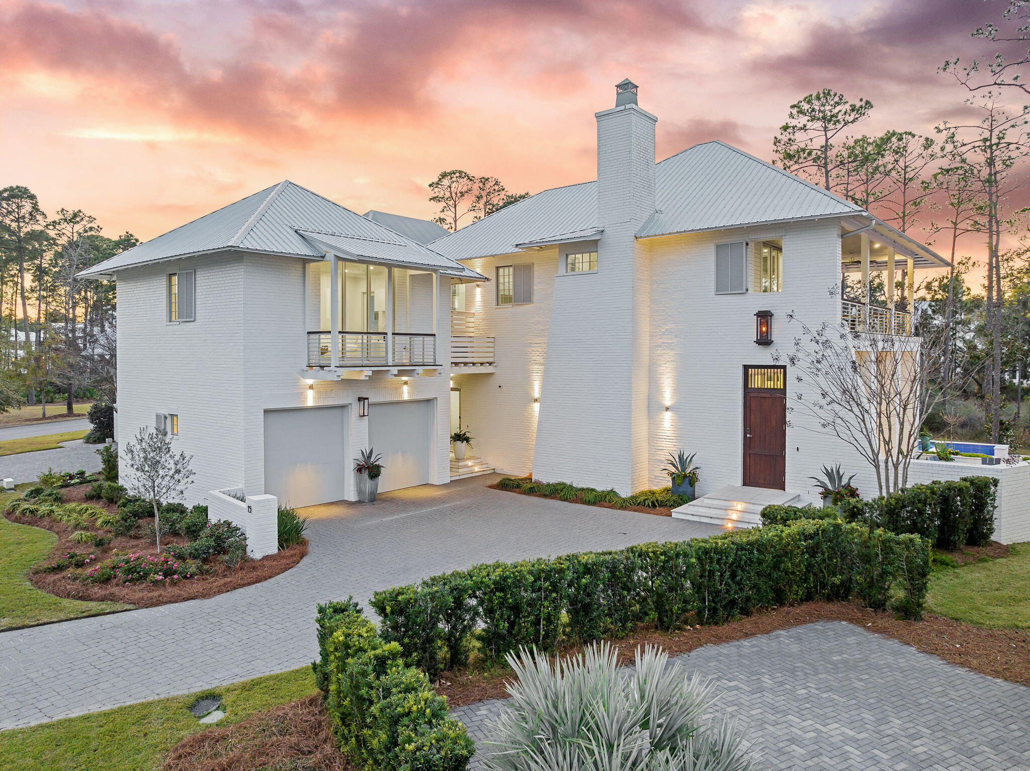 a front view of a house with a yard and potted plants