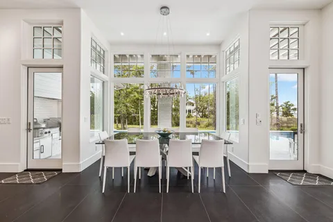 a dining hall with stainless steel appliances granite countertop furniture and a wooden floor